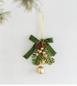 Macro detail of Christmas hanging decor with green velvet bow, pine cones and gold bells