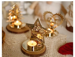 Detail of golden hollow metal candle holders in star, heart, and tree shapes for table decor