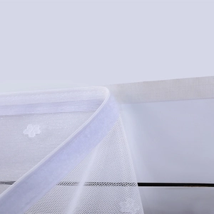 Close-up of white lace dust cover with fine mesh, flower embroidery and adhesive velcro