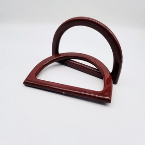 Macro detail of glossy wine red resin D-shape handles for DIY handmade handbags