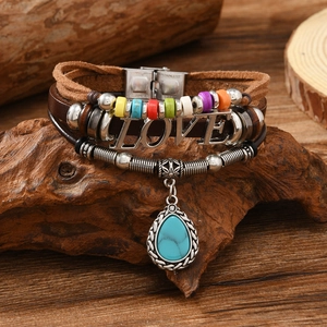 Detail of leather bracelet featuring turquoise pendant and engraved LOVE metal plate