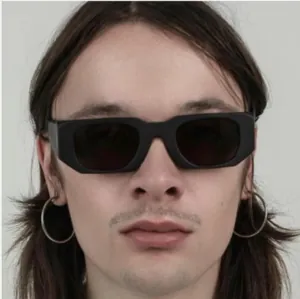 Detail view of stylish black rectangular oversized sunglasses worn by a fashion model