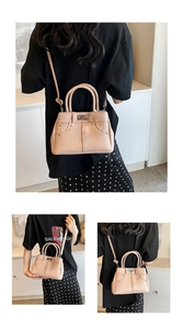 Vertical view of a light pink textured crossbody bag worn on a model's back and side
