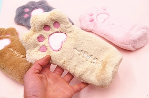 Close-up of plush cartoon cat paw fingerless gloves with soft fur and pink embroidery