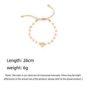 Detailed macro view of heart pendant pearl bracelet with adjustable woven string clasp