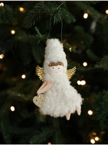 Close-up of a white plush angel ornament with golden wings on a Christmas tree branch