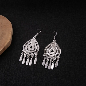 Detailed view of silver ethnic leaf tassel earrings with hollow teardrop design and fringe