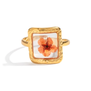 Detailed shot of a gold hammer-textured square ring featuring a real orange dried flower
