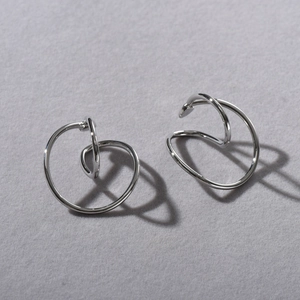Close-up of minimalist silver geometric double-loop ear cuffs with sleek metallic finish