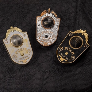 Three vintage glowing Halloween doorbells with embossed eye design on spiderweb background