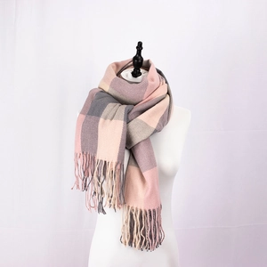 Detail of pink and grey plaid scarf featuring soft cashmere-like texture and long fringes