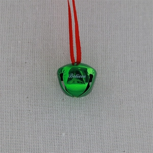 Detail of green Christmas bell ornament with Believe engraving and red string loop