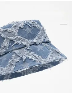 Detail of frayed star pattern and denim texture on wide brim fisherman sun hat