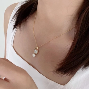 Elegant gold necklace with cat shell pendant and white pearl on model neck