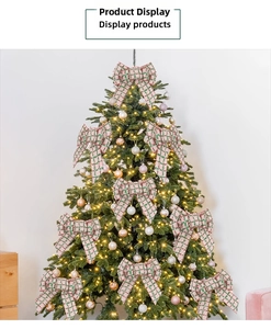 Close-up of pink and green plaid burlap bows decorated on a Christmas tree with warm lights
