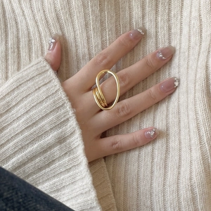 Golden multi-layer twisted geometric S925 silver ring worn on hand with knit background