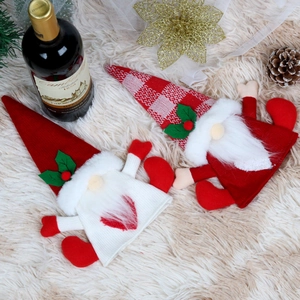 Christmas gnome wine bottle covers in red and white knit on white plush background