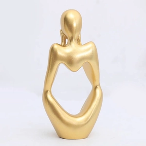 Detailed close-up of a modern minimalist gold abstract figure sculpture with matte finish