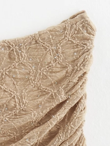 Détail de dentelle beige avec texture florale 3D et sequins brillants sur le tissu