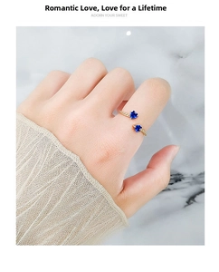 Detail of gold-plated open ring featuring two blue heart-shaped zircons on hand
