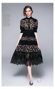 Detail of elegant black polka dot midi dress featuring tiered lace hem and stand collar