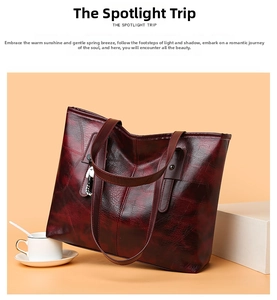 Detail of burgundy wax leather tote bag with metallic buckles and shoulder strap