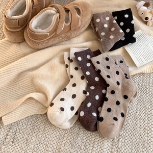 Chaussettes en laine à pois aux couleurs automnales dans une ambiance chaleureuse