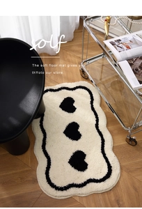 Close-up of thick plush heart pattern bath mat on light wood floor in modern bathroom