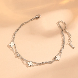 Detail of silver double-layer stainless steel anklet with clover charms and cubic zirconia