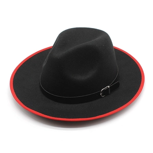 Detail of black wool fedora featuring a striking red brim edge and leather buckle band