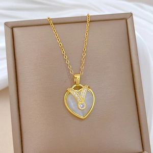 Macro view of gold heart pendant with cat eye stone and diamonds on silk