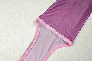 Dettaglio del tessuto a rete viola con bordo rosa e cuciture rinforzate sull'abito