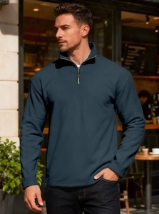 Detail of navy blue half-zip sweatshirt with a metallic zipper and standing collar