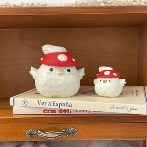 Detail of mushroom-capped bird figurines with wood-like texture on a stack of books