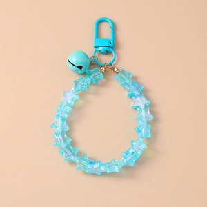 Macro detail of a blue star-shaped bead keychain with a matching metal bell and hook