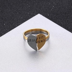 Macro detail of gold and silver heart-shaped puzzle rings with Best Friend engraving