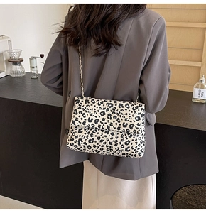 Detail of trendy leopard print crossbody bag with sleek metal chain strap on model