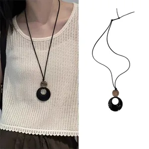 Minimalist resin ring pendant necklace on black leather cord with wood texture details