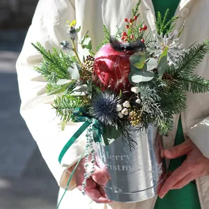 Seau de Noël argenté avec pomme rouge et décoration florale festive élégante