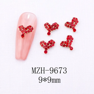 Detail showing 9x9mm red heart nail charms with micro rhinestones and gold alloy base