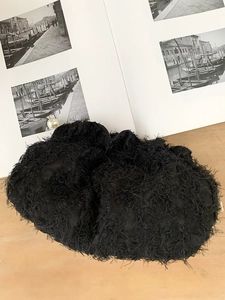 Détail d'une pochette en dentelle noire à texture plumes avec décor de perles chic