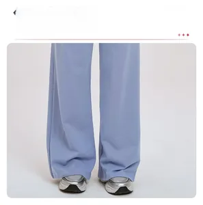 Detail view of light blue wide leg track pants with a straight fit and draped fabric look