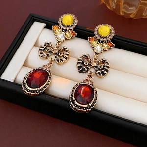 Vintage style drop earrings with red oval gemstone and sparkling diamond bow accent