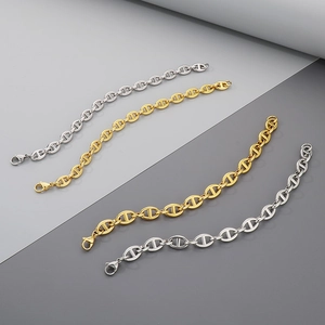 Detail of interlocking pig nose coffee bean chain bracelets in gold and silver finish