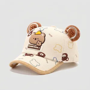 Detalle de orejas de oso de peluche y bordado de dibujo en gorra infantil de algodón