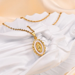 Detailed macro view of gold oval Virgin Mary pendant necklace on white elegant statue