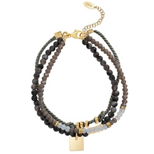 Detailed macro of handmade colorful stone beads with gold lobster clasp and square tag