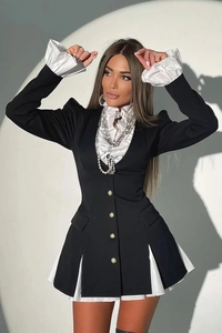 Detail of contrast button-up shirt dress featuring white ruffled cuffs and gold buttons