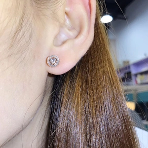 Close-up of rose gold heart stud earring with halo crystal settings and central stone