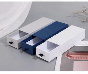Three-color textured drawer gift boxes in gray, navy, and white with ribbon handles